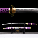 Purple-handled Katana with gold accents on display stand, black background, showcasing elegant craftsmanship. Nidai Kitetsu Katana.
