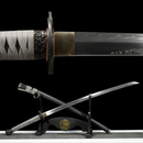 A detailed close-up of the blade and handle of a katana, with wave patterns and intricate hilt design, displayed on a stand. Elden Ring M...
