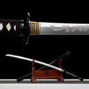 Intricately engraved katana on wooden stand; detailed black handle and sheath, dragon design, gold accents. Koi Katana Koi.